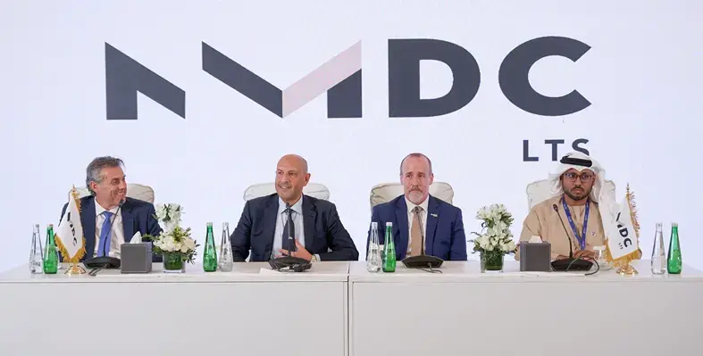 Four men sitting at a table for a signing ceremony